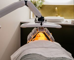 Client resting under a LED light therapy lamp