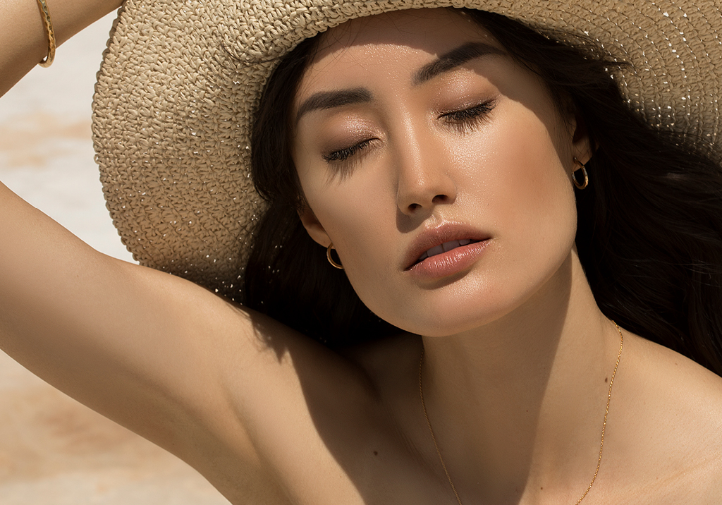 Woman basking in the sun with a hat